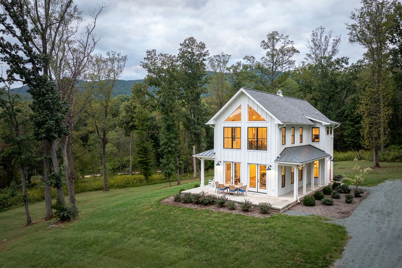 Hilltop House with its windows lit, and the Blue Ridge rising behind the trees